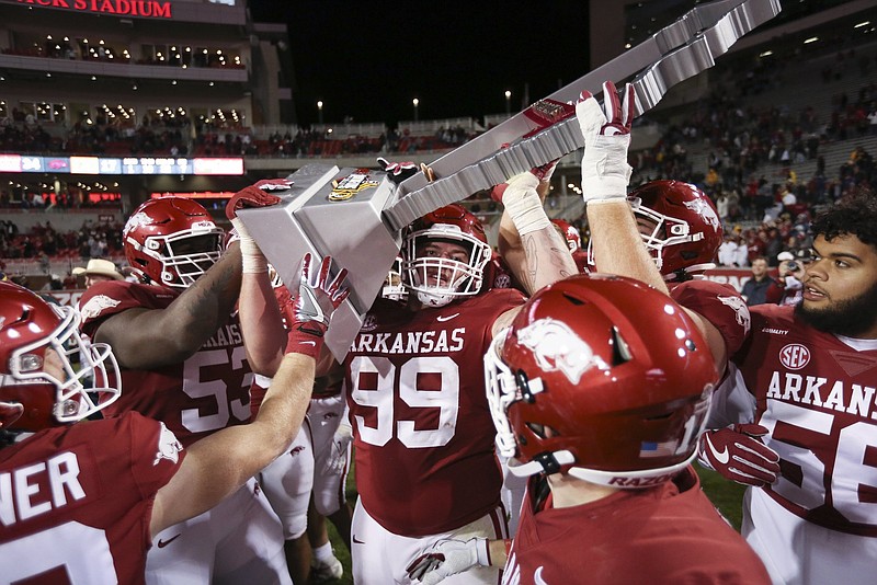 Arkansas players celebrate with the Battle Line Trophy after the Razorbacks defeated Missouri 34-17 on Friday at Reynolds Razorback Stadium in Fayetteville. Arkansas won all three of its trophy games against Texas A&M, LSU and Missouri for the first time since Missouri became an annual rival in 2014. More photos at arkansasonline.com/1127muua/
(NWA Democrat-Gazette/Charlie Kaijo)