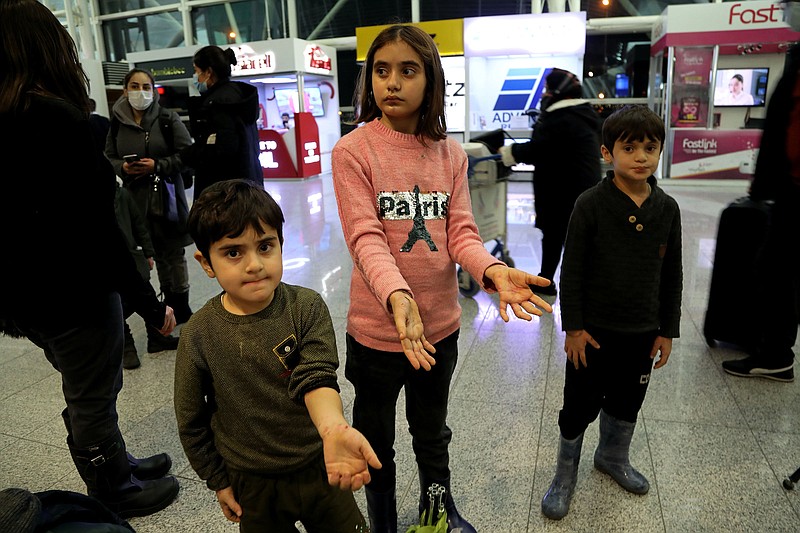 Children of the Iraqi migrants show hands with wounds and infections after arriving Friday at the airport in Irbil, Iraq.
(AP/Hussein Ibrahim)