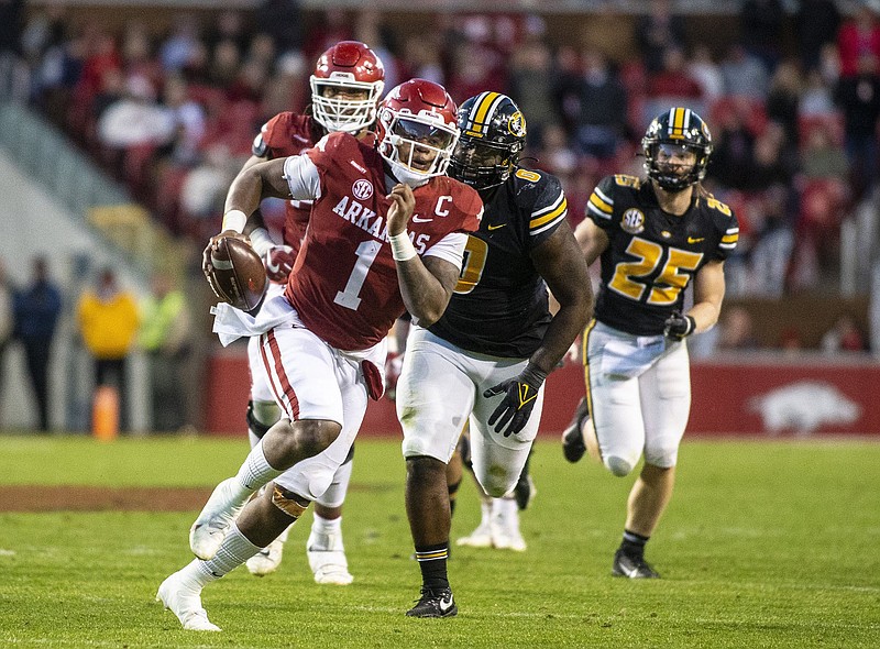 Arkansas quarterback KJ Jefferson runs with the ball in front of two Missouri defenders Friday during the second half of the No. 25 Razorbacks’ 34-17 victory over the Tigers at Reynolds Razorback Stadium in Fayetteville. Jefferson led the Razorbacks in rushing with six carries for 58 yards, including a 49-yard run on Arkansas’ first series of the game, and completed 15 of 19 passes for 262 yards. More photos at arkansasonline.com/1127muua/.
(Special to the NWA Democrat-Gazette/David Beach)