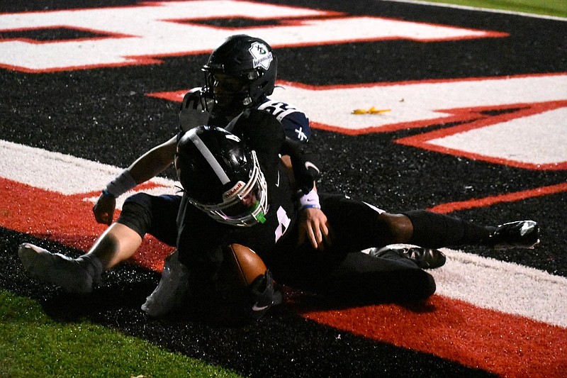 White Hall receiver Steven Weston (4) rolls over after a touchdown catch with Little Rock Christian linebacker Ben Ridings (22) covering him in the second quarter Friday in a 5A state semifinal game at White Hall. 
(Pine Bluff Commercial/I.C. Murrell)