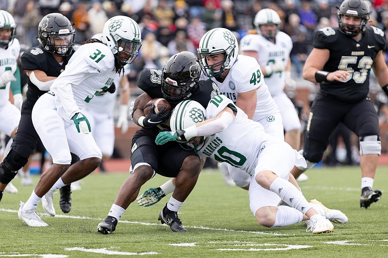 Northwest Missouri?s defensive back Drew Dostal (front right) tackles Harding?s running back Omar Sinclair (middle) Saturday during the second-round Division II playoff game at First Security Stadium in Searcy. (Arkansas Democrat-Gazette/Justin Cunningham)