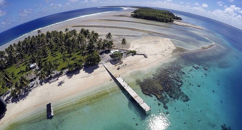 An aerial photo shows a small section of the atoll that has slipped beneath the water line, only showing a small pile of rocks at low tide, on Majuro Atoll in the Marshall Islands on Nov. 8, 2015. For decades, the tiny nation of the Marshall Islands has been a stalwart American ally. Its location in the middle of the Pacific Ocean has made it a key strategic outpost for the U.S. military. (AP/Rob Griffith)