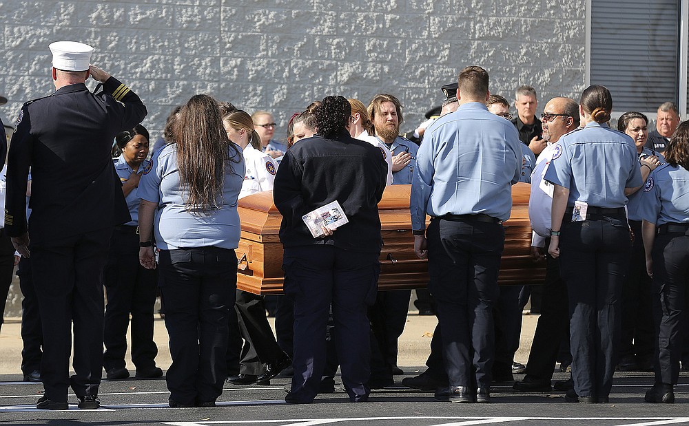 First responders pay their respects Wednesday as pallbearers carry the casket of MEMS paramedic Maj. Dean Douglas to an ambulance after Douglas’ funeral at First Assembly of God Church in North Little Rock.
(Arkansas Democrat-Gazette/Thomas Metthe)