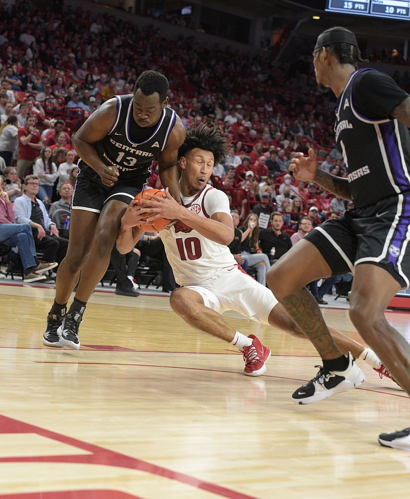 Arkansas’ Jaylin Williams (10) fights for a loose ball with Central Arkansas’ Eddy Kayouloud during the Razorbacks’ victory over the Bears on Wednesday night. Arkansas hosts UALR on Saturday, marking the first time since 1925-26 that the Hogs have faced multiple in-state teams in the same season.
(NWA Democrat-Gazette/Hank Layton)