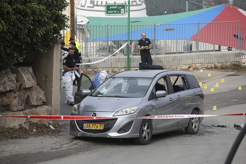 Police examine a car Friday after a man was shot dead by Israeli police, following a night of violence in Umm el-Fahm, Israel.
(AP/Mahmoud Illean)