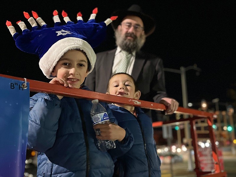 (Left to right) Six-year-old Mendel Kramer, and his brother, 5-year old Binyamin Kramer, joined Rabbi Pinchus Ciment on the lift, Sunday, a short distance above the ground, after it had been used to reach the top of a menorah in west Little Rock. Sunday was the first day of Hanukkah.
(Arkansas Democrat-Gazette/Frank E. Lockwood)