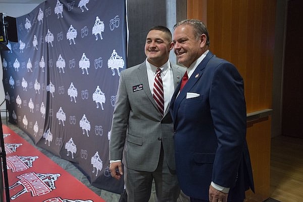 Arkansas linebacker Grant Morgan (left) and coach Sam Pittman pose for a photo prior to the presentation of the Burlsworth Trophy on Monday, Dec. 6, 2021, at Crystal Bridges Museum of American Art in Bentonville.