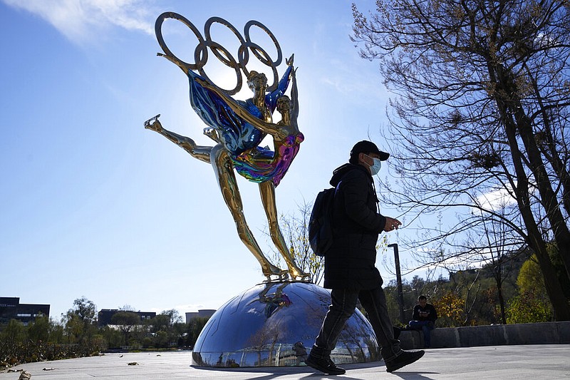 A visitor to the Shougang Park walks past the a sculpture for the Beijing Winter Olympics in Beijing, China, Tuesday, Nov. 9, 2021. (AP/Ng Han Guan)