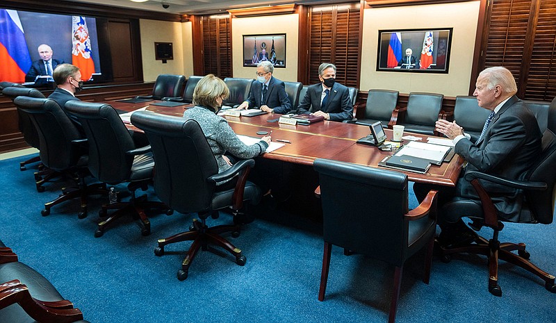 A photo provided by the White House shows U.S. President Joe Biden, right, at the White House in Washington, as President Vladimir Putin of Russia appears on video monitors during their virtual meeting on Tuesday, Dec. 7, 2021. Secretary of State Antony Blinken, second from right, and other officials also attended. (White House via The New York Times)  -- FOR EDITORIAL USE ONLY. --