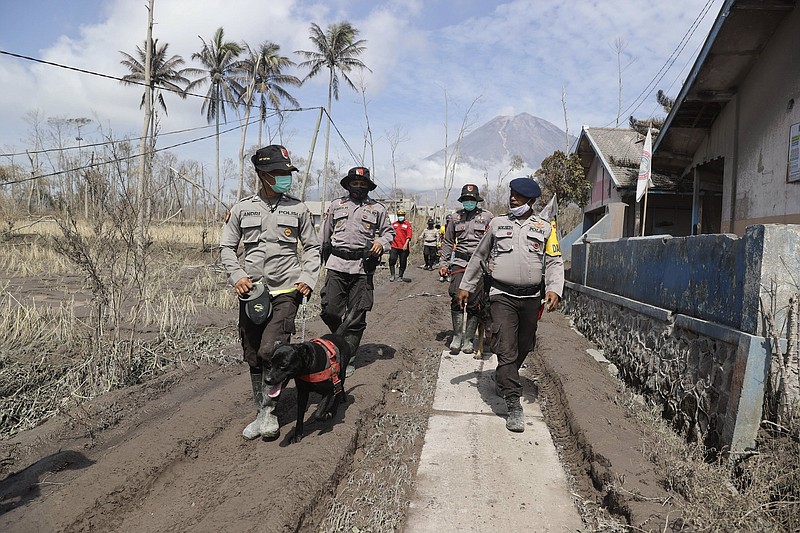 Police officers on Indonesia’s Java island search for victims earlier Wednesday after the eruption of Mount Semeru.