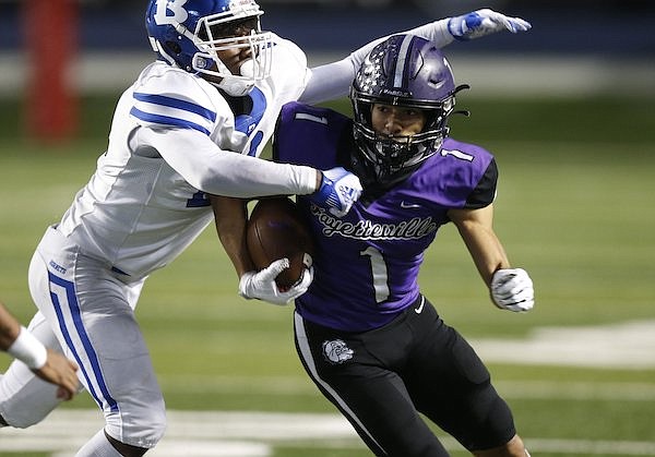 Bryant cornerback Jonah Brewster (20) tackles Fayetteville wide receiver Isaiah Sategna (1) during the second quarter of the Class 7A state championship game on Saturday, Dec. 4, 2021, at War Memorial Stadium in Little Rock.