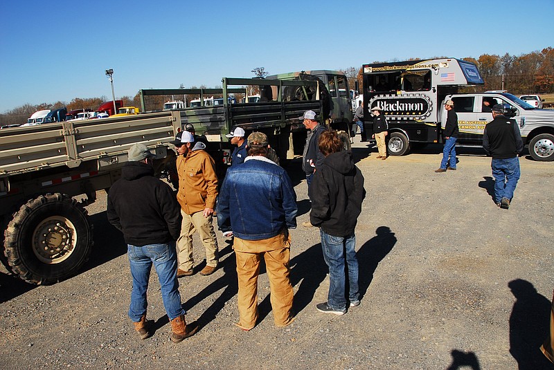 Bidders check out a surplus military truck and trailer on the auction block Wednesday at the Blackmon Auctions’ Arkansas Auction Complex in Lonoke.
(Arkansas Democrat-Gazette/Noel Oman)