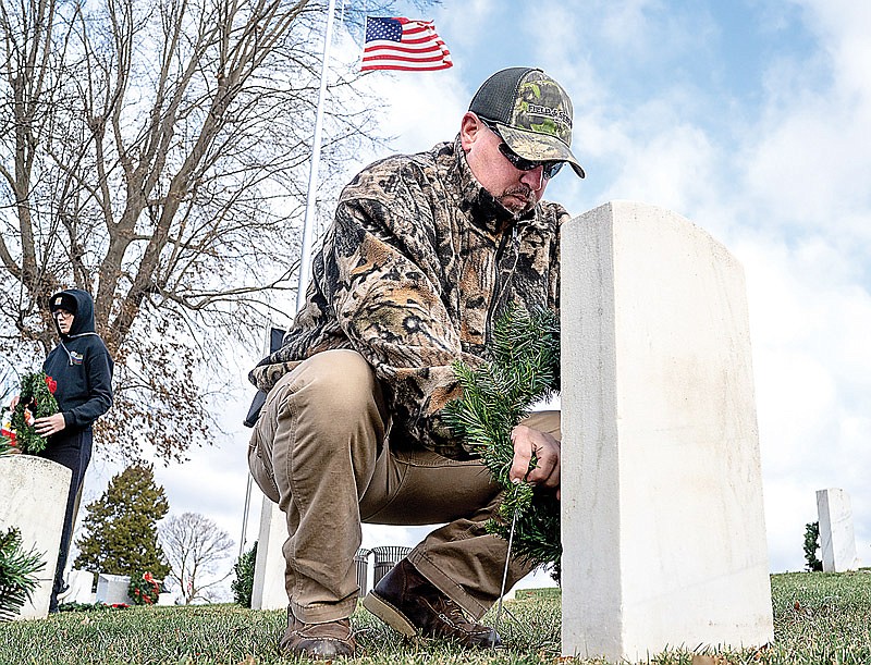 Mark Boessen lays a wreath at the grave of a soldier buried in the Jefferson City National Cemetery during the 12th annual Wreath’s for Heroes event on Saturday, Dec. 11, 2021 in Jefferson City, Mo. Those that came out laid 1792 wreaths — one for each grave marker in the cemetery.