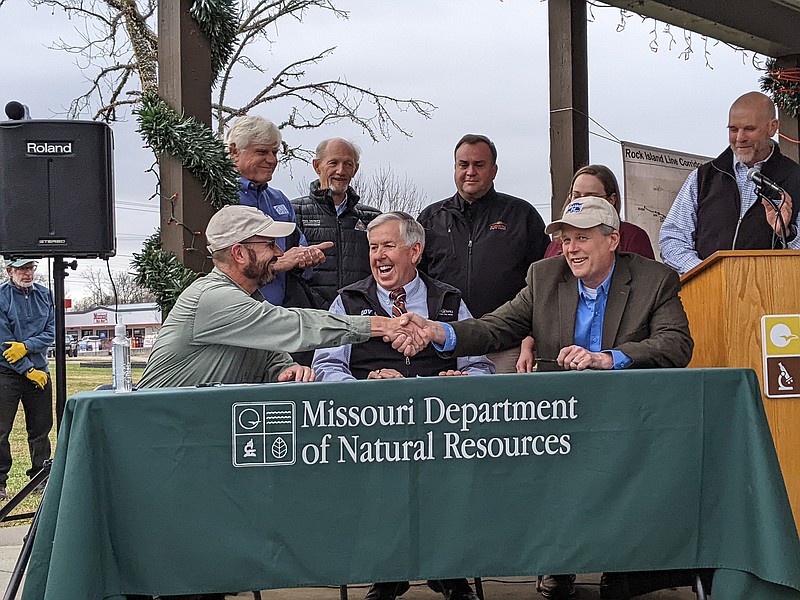 Missouri Department of Natural Resources Director Dru Buntin shakes hands with Mark Birk, senior vice president for customer and power operations at Ameren, on Dec. 14, 2021, after signing the land donation agreement. DNR and Missouri State Parks now own the Rock Island Corridor.