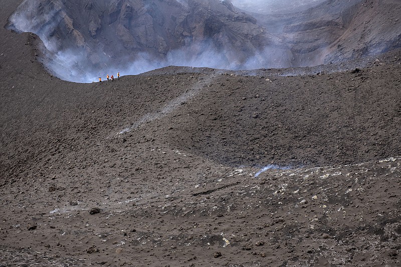 Scientists walk near the edge of the crater Wednesday at the Cumbre Vieja volcano in the Canary Islands of La Palma, Spain.
(AP/Saul Santos)