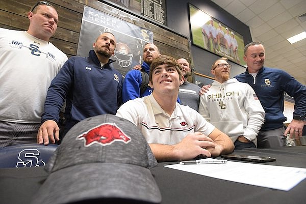 Shiloh Christian linebacker Kaden Henley (seated) smiles during a signing day ceremony Wednesday, Dec. 15, 2021, in Springdale.