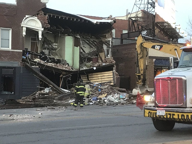 Crews work at the scene early Thursday after a fire truck and sport utility vehicle collided late Wednesday, sending the SUV crashing into this building in Kansas City, Mo.
(AP/The Kansas City Star/Rich Sugg)