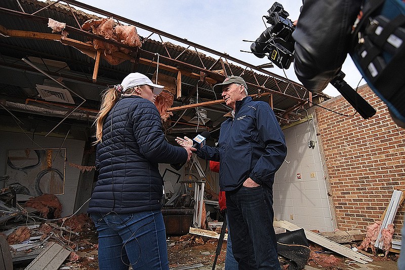 Gov. Asa Hutchinson answers questions from Hunter Davis, a Fox News reporter, on Saturday, Dec. 11, 2021, inside of Monette Manor after a tornado tore through the town of Monette the night before. (Arkansas Democrat-Gazette/Staci Vandagriff)
