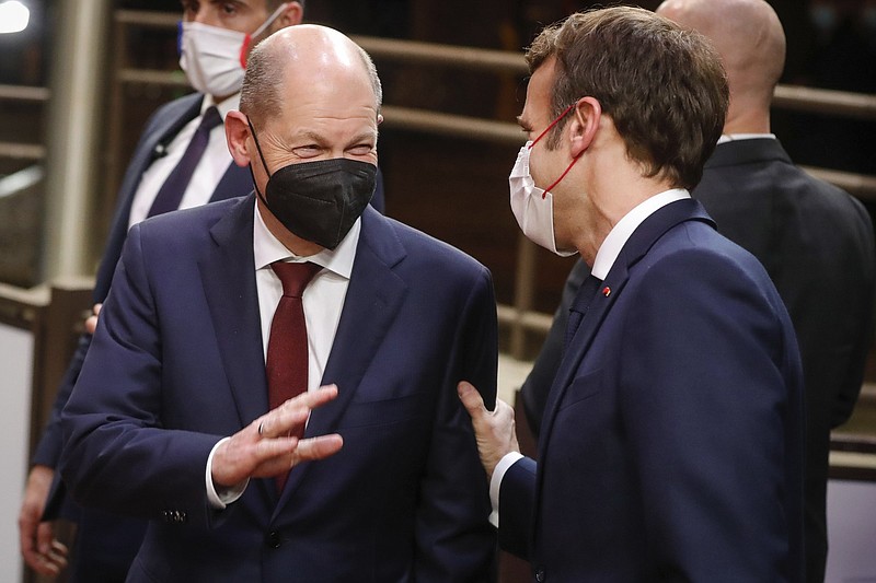 German Chancellor Olaf Scholz (left) and French President Emmanuel Macron speak with each other during departures at the end of an EU Summit on Friday in Brussels.
(AP/Stephanie Lecocq)