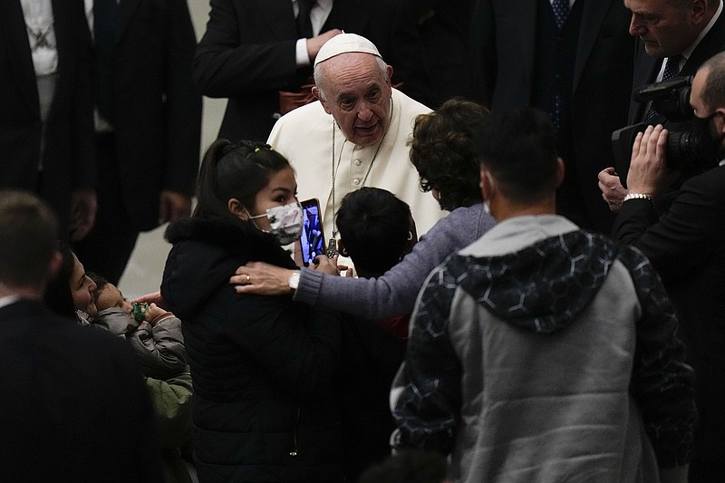 Pope Francis talks Wednesday at the end of his weekly general audience at the Vatican with an Afghan family he met at a refugee camp in Greece earlier this month and helped move to Italy.
(AP/Alessandra Tarantino)