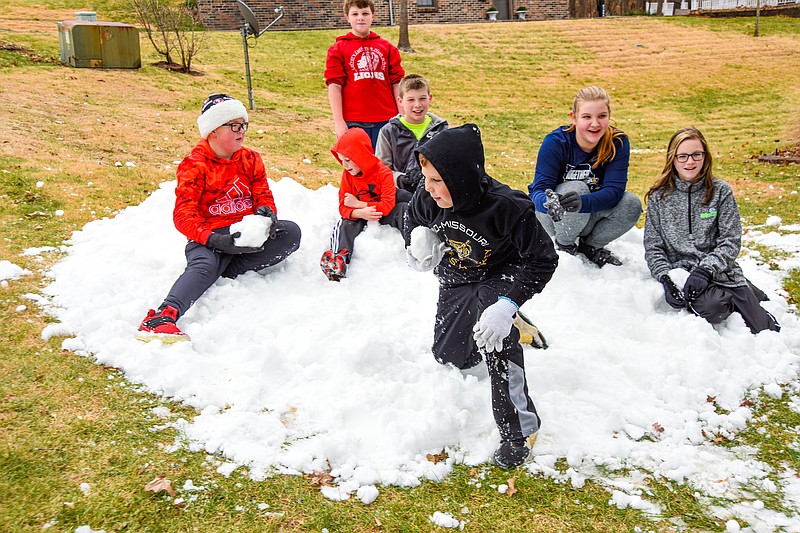 Tucker Gates jumps from the pile of ice shavings Thursday as he and friends played in and around them. From left are Jesse Volmert, Ethan Farris (standing), Oliver Gates, Russell Briggs, Sydney Volmert and Shiloh Shaefer. Sydney and Jesse Volmert were the recipients of the cold, wet stuff. As has been tradition for about 30 years, Jefferson City Parks, Recreation and Forestry Department delivered a dump truck load of ice arena shavings the week before Christmas. This year's recipient was the Volmert family on Carl Lane on the city's east side. When the truck arrived, he was greeted by several excited youth who couldn't wait to jump in the shavings. (Julie Smith/News Tribune)