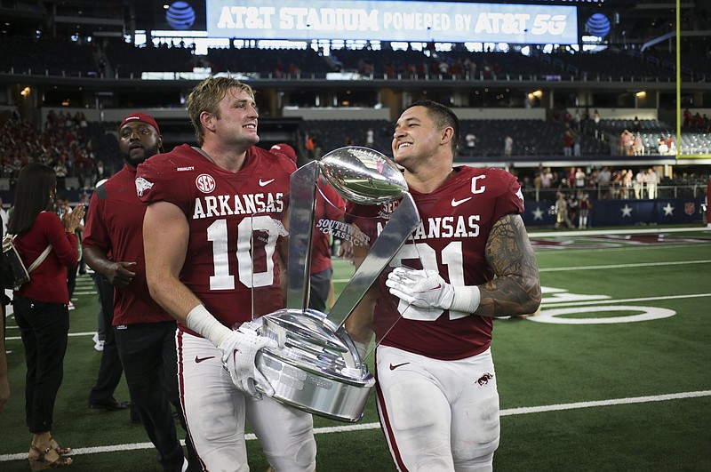 Arkansas linebacker Bumper Pool (10) and linebacker Grant Morgan (31) carry the Southwest Classic trophy, Saturday, September 25, 2021 at the end of a football game at AT&T Stadium in Arlington, Texas. Check out nwaonline.com/210926Daily/ for today's photo gallery. .(NWA Democrat-Gazette/Charlie Kaijo) Arkansas linebacker Bumper Pool (10) and linebacker Grant Morgan (31) carry the Southwest Classic trophy, Saturday, September 25, 2021 at the end of a football game at AT&T Stadium in Arlington, Texas. Check out nwaonline.com/210926Daily/ for today's photo gallery. .(NWA Democrat-Gazette/Charlie Kaijo)