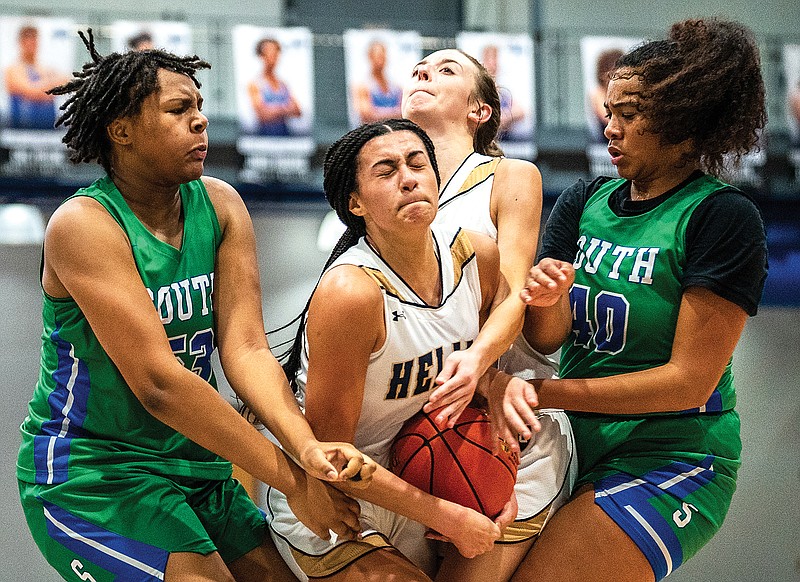 Claire Manns (center) of Helias tries to maintain control of the ball between Blue Springs South’s Kendall Puryear (left) and Alexis Alexander (right) during Tuesday’s game in the Jefferson Bank Holiday Hoops Tournament at Capital City High School. (Ethan Weston/News Tribune)