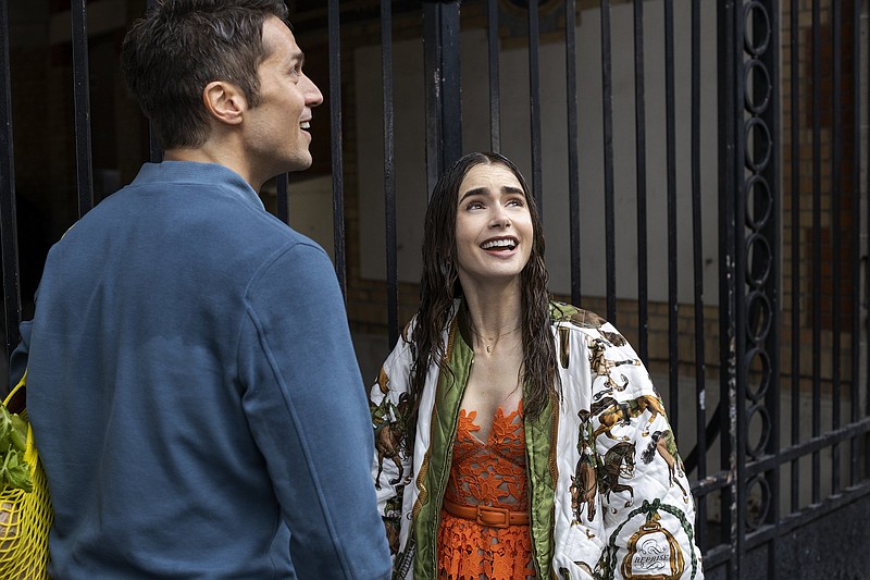 Emily Cooper (Lily Collins) gets stuck in the rain with her hot chef neighbor, Gabriel (Lucas Bravo), in the new season of “Emily in Paris.” (Netflix/Carole Bethuel)