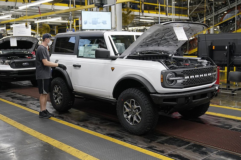 A worker examines a 2021 Ford Bronco on the line at an assembly plant in Wayne, Mich., earlier this year. Ford introduced the vehicle in June 2020 and began delivering it in June 2021.
(AP/Carlos Osorio)