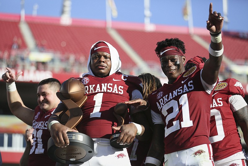 Arkansas quarterback KJ Jefferson (center), who was named the game’s Most Valuable Player, and teammates, including Grant Morgan (left) and Montaric Brown, celebrate their 24-10 victory over Penn State in the Outback Bowl on Saturday at Raymond James Stadium in Tampa, Fla. More photos at arkansasonline.com/12outback22/
(NWA Democrat-Gazette/Charlie Kaijo)