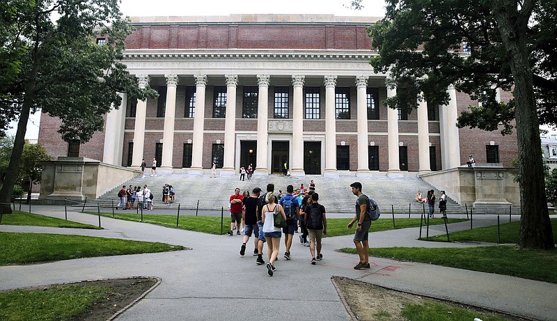 Students file past the Widener Library at Harvard University in Cambridge, Mass., in 2019. Harvard and dozens of other colleges and universities are going back to online classes while coronavirus infections continue to spike.
(AP/Charles Krupa)