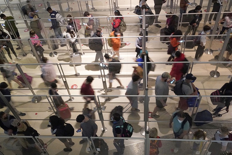 Plexiglass partitions separate travelers as they make their way through the security line Friday at Love Field in Dallas. Major airlines continued to cancel flights Saturday because of staff shortages and bad weather.
(AP/LM Otero)