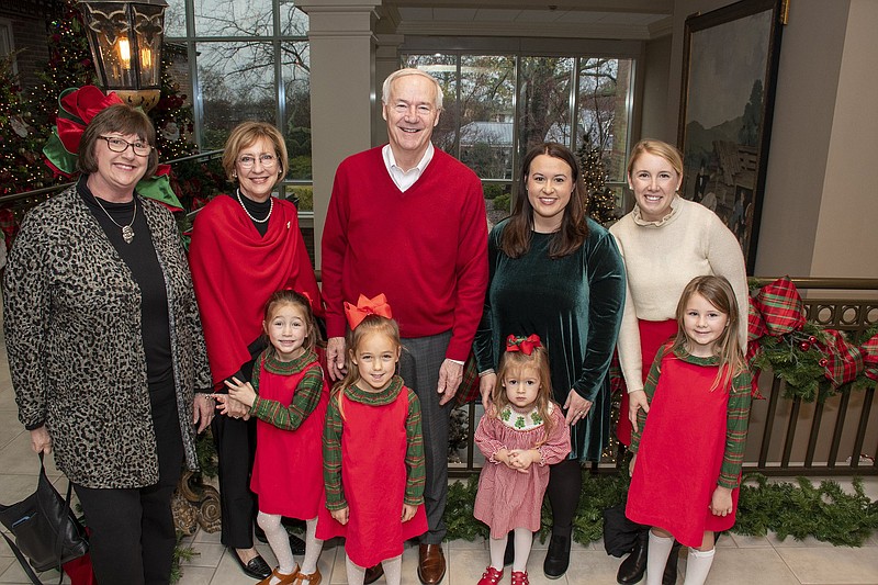 Marilyn Roth, Nancy Moore, Gov. Asa Hutchinson, Lana Roth and Sarah Moore with (in front) Eva Moore, Dylan Moore, Ryleigh Roth and Ellie Moore on 12/18/21 at the Governor's Mansion (Arkansas Democrat-Gazette/ Cary Jenkins)