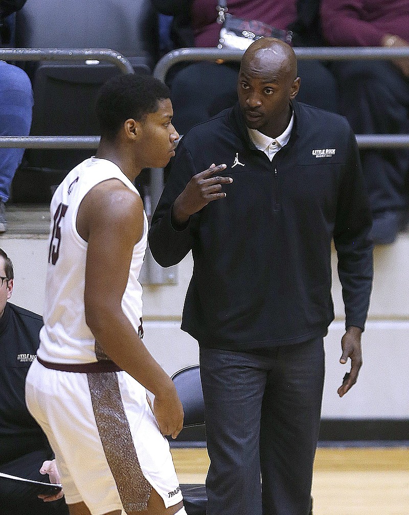 UALR assistant coach Julius Hodge talks with guard Myron Gardner (15) as he leaves the court during the second half of the Trojans' 78-66 win on Thursday, Dec. 30, 2021, at the Jack Stephens Center in Little Rock. .More photos at www.arkansasonline.com/1231ualr/.(Arkansas Democrat-Gazette/Thomas Metthe)