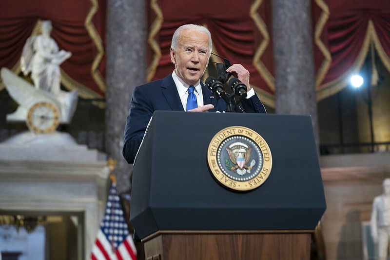 President Joe Biden takes off his face mask as he speaks from Statuary Hall at the U.S. Capitol to mark the one year anniversary of the Jan. 6 riot at the Capitol by supporters loyal to then-President Donald Trump, Thursday, Jan. 6, 2022, in Washington. (Greg Nash/Pool via AP)