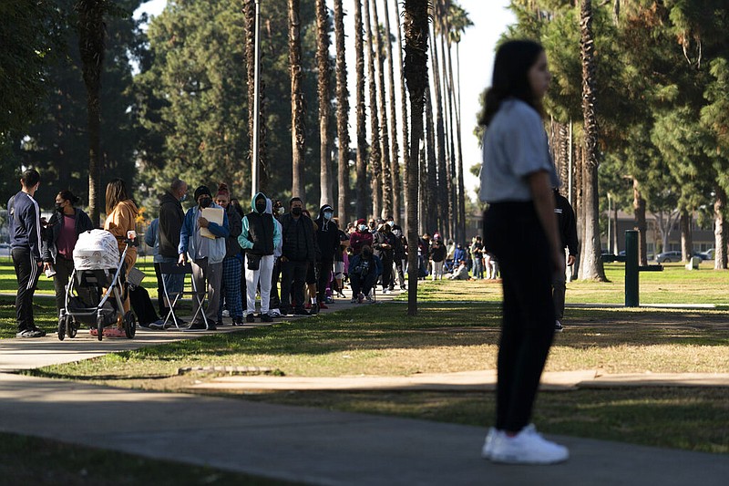 People wait in line for a rapid antigen test at a covid-19 testing site in Long Beach, Calif., on Thursday, Jan. 6, 2022. Millions of workers whose jobs don’t provide paid sick days are having to choose between their health and their paycheck as the omicron variant of covid-19 rages across the nation. (AP/Jae C. Hong)