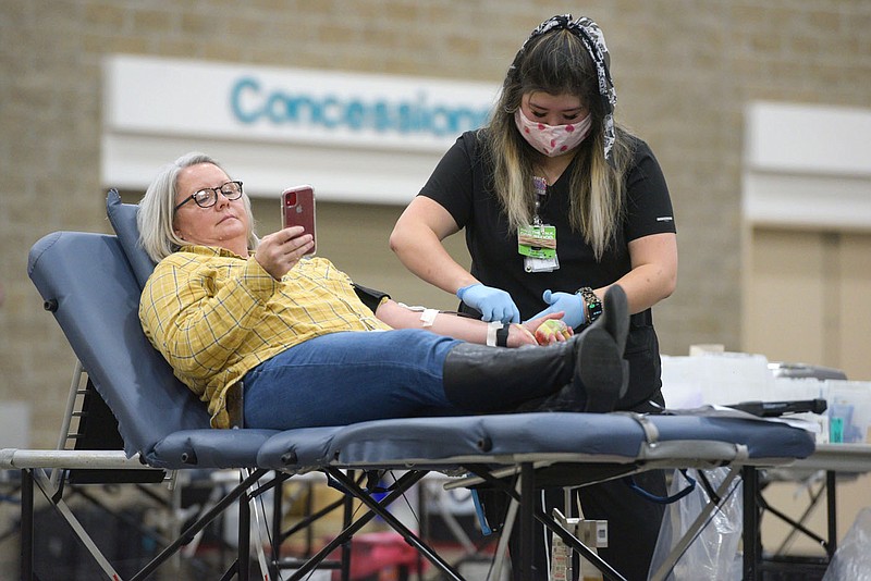 Kerry Hensley (left) of Greenwood donates blood as phlebotomist Kim Chen supervises during an annual holiday blood drive hosted by the Arkansas Blood Institute inside the Fort Smith Convention Center in this Dec. 29, 2021, file photo. (NWA Democrat-Gazette/Hank Layton)