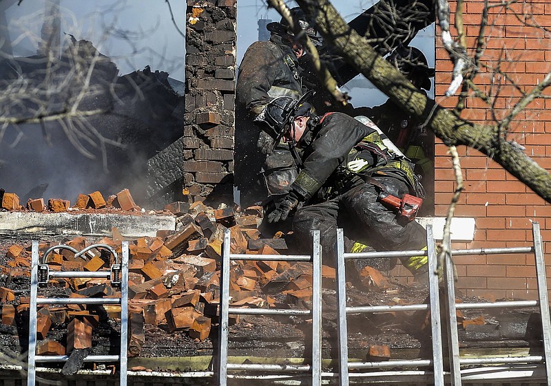 A firefighter reacts after a pile of bricks falls on him from a window as co-workers battle a blaze Thursday in St. Louis.
(AP/St. Louis Post-Dispatch/Colter Peterson)