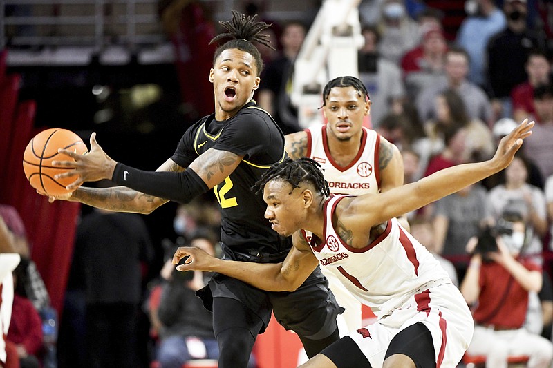 Missouri guard DaJuan Gordon pulls down a rebound in front of Arkansas teammates JD Notae (1) and Stanley Umude (0) during Wednesday night's game in Fayetteville, Ark. (The Associated Press)