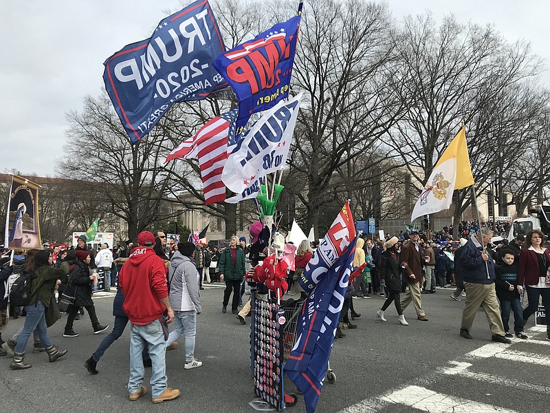 At the 2020 National March for Life in Washington, a marcher carrying a yellow-and-white Vatican flag marches past a vendor selling “Trump 2020” banners, several yards ahead of a banner for St. Joseph’s Parish in New York. While the Catholic Church took the lead in opposing legalized abortion, the movement now includes massive numbers of evangelical Christians as well.
(Arkansas Democrat-Gazette/Frank E. Lockwood)