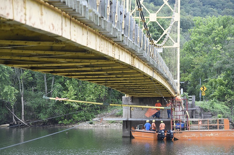 Bridge repairers begin to install a safety system in preparation to replace the old deck of the Beaver Bridge over the White River in Beaver, north of Eureka Springs, in this Sept. 3, 2020, file photo. The Arkansas Department of Transportation was installing cables as part of a project to repair the decking and rails of the 1943 bridge. (NWA Democrat-Gazette/Charlie Kaijo)