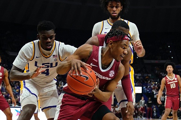 Arkansas guard JD Notae tries to pass the ball under pressure from LSU forward Darius Days (4) in the first half of an NCAA college basketball game in Baton Rouge, La., Saturday, Jan. 15, 2022. (AP Photo/Gerald Herbert)
