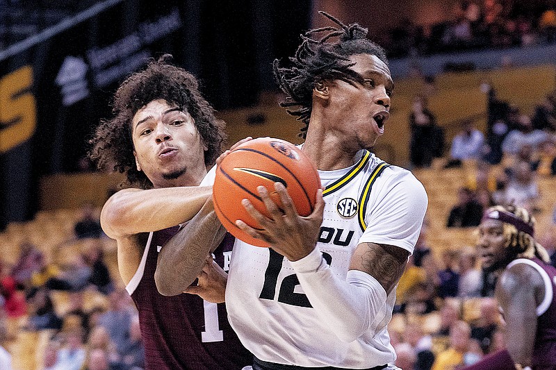 Texas A&M’s Marcus Williams tries to steal the ball from Missouri’s DaJuan Gordon during Saturday’s game at Mizzou Arena. (Associated Press)