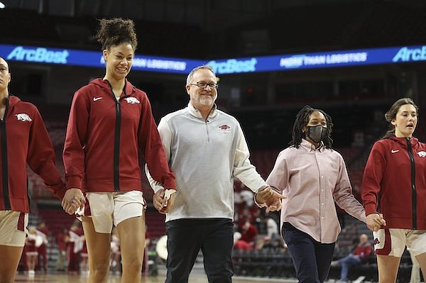 Arkansas coach Mike Neighbors (center) walks onto the floor with his team prior to a game against Missouri on Sunday, Jan. 9, 2022, in Fayetteville.