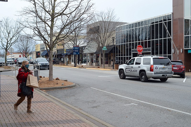 Pedestrians walk Friday, Jan. 14, 2022, along Emma Avenue in downtown Springdale. Downtown Springdale has put together a public survey about the Downtown Master Plan for the city. (NWA Democrat-Gazette/Andy Shupe)