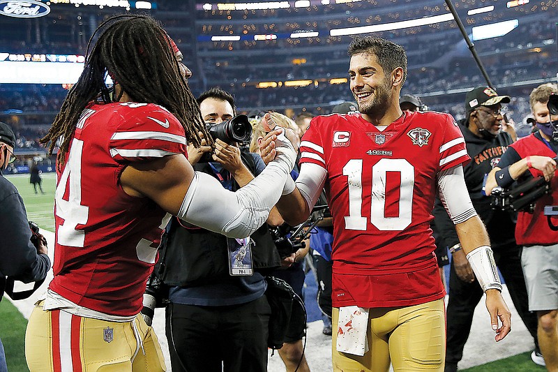 49ers middle linebacker Fred Warner (left) celebrates with quarterback Jimmy Garoppolo after Sunday’s 23-17 win against the Cowboys in Arlington, Texas. (Associated Press)