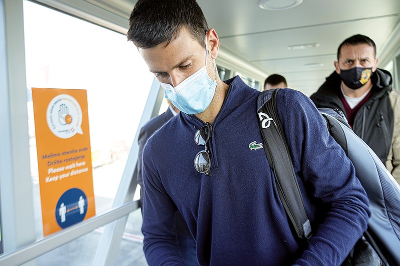 Novak Djokovic looks as his documents after landing Monday in Belgrade, Serbia. (Associated Press)