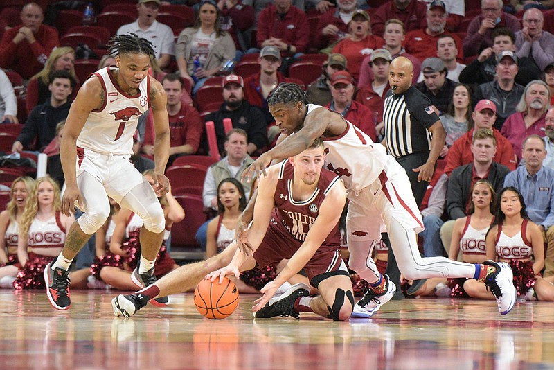 JD Notae (1) and Davonte Davis (4) of the Arkansas Razorbacks wrestle Erik Stevenson (10) of South Carolina for a loose ball on Tuesday, Jan. 18, 2022, during the second half of the Razorbacks' 75-59 win over the Gamecocks at Bud Walton Arena in Fayetteville. Visit nwaonline.com/220119Daily/ for today's photo gallery..(NWA Democrat-Gazette/Hank Layton)