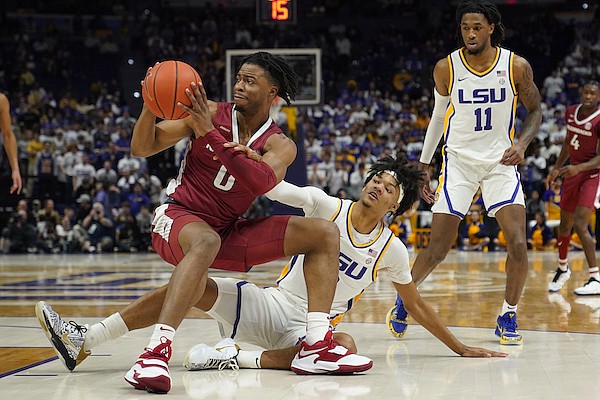 Arkansas guard Stanley Umude, left, and LSU forward Alex Fudge battle on the floor for a loose ball in the first half of an NCAA college basketball game in Baton Rouge, La., Saturday, Jan. 15, 2022. (AP Photo/Gerald Herbert)