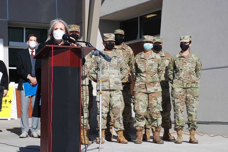 New Mexico Gov. Michelle Lujan Grisham (foreground) announces efforts to temporarily employ National Guard troops and state bureaucrats as substitute teachers and preschool caregivers during a news conference at Sante Fe High School in Santa Fe, N.M., on Tuesday, Jan. 19, 2022. New Mexico is struggling to keep classrooms open amid surging covid-19 infections. (AP/Morgan Lee)